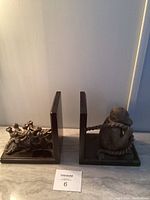 Front view of both bookends showing the monkey figurine and gorilla group on the tree branch, both mounted on square bases.