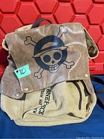 Front view of backpack with leather flap showing One Piece Straw Hat Crew skull logo