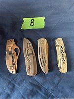 Photo of four closed silver folding pocket knives showing handles.
