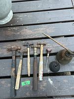 Full lot laid on wooden surface including 5 vintage ball peen hammers with wooden handles, 2 oil cans, and Stanley pick.