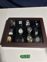 Closed watch case holding 12 watches under glass lid