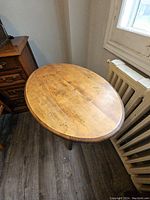 Top view of oval wooden table surface showing wood grain and condition.