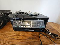 Photo of Epson WorkForce 545 printer on wood table with cords and control panel visible