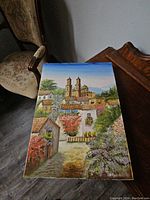 Print showing village scene with church, houses, and foliage