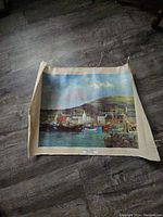 Full view of the canvas print showing a harbor scene including boats, buildings and a mountain backdrop with unfinished edges