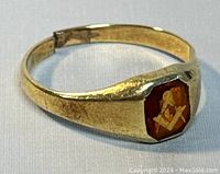 Close-up front view of the ring showing the red enamel Masonic symbol on top.
