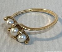 Close-up of the ring showing the three pearls and curved band with 10K hallmark.