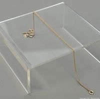 Anklet draped on clear acrylic display, showing overall length and link style