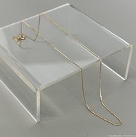 Chain displayed on clear riser against white background showing full length and drape.