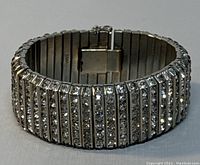 Front view showing the wide rhinestone rows and metal bands of the bracelet cuff.