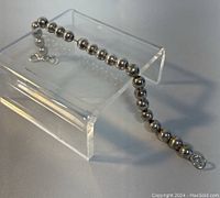 Full view of the 8-inch 925 silver bead bracelet displayed on a clear stand.