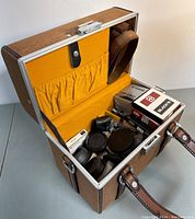 Interior view showing vintage case interior with lens caps, filter boxes and accessories