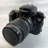 Front view of Canon EOS A2 camera with attached 35-105mm lens with Canon lens cap on.