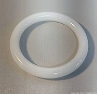 Top view showing the smooth, polished surface and circular shape of the white jade bangle.