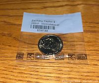 Front side of the 2009-P Zachary Taylor US dollar coin sealed in plastic with label showing coin type and uncirculated-60 grade.