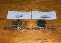 Front and back view of two sealed uncirculated Massachusetts $1 coins from 2020, showing details and packaging.