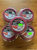 Five rolls of Copperhead Red Commercial .080 inch diameter grass trimmer line, still in original sealed packaging, displayed together.