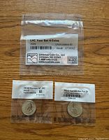 Four 2009 Lincoln Head cent coins sealed in a plastic pouch labeled by Littleton Coin Co showing uncirculated 60 condition, along with two other coins in separate sealed holders.