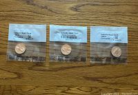 Three sealed proof Lincoln Head cent coins from 1993, 1994, and 1998, placed side by side showing obverse sides.