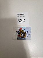 Photo of holographic Ottawa Senators sticker card with Nick Foligno's signature in black ink.