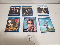 Photo of 6 Blue Ray DVD cases on white surface, arranged in two rows of three.