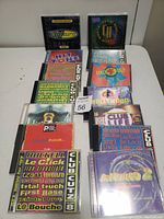 Thirteen dance and club music CDs arranged in several rows on a white surface, showing the front covers of each CD case.