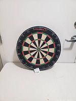 View of HDUX dartboard in good condition on a white background, showing full dartboard face and numbers.