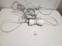Two white outdoor WiFi cameras with long cables and mounting brackets on a flat surface, showing overall lot contents.