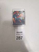 Front view of The McFarlane Era Spider-Man card set housed in a clear protective case with Spider-Man illustrations visible on the front card.