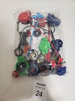 Bag of assorted spinning kids top toys including colorful tops, launchers, and ripcords.