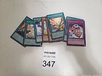 Seven Yu-GI-OH cards spread out showing holographic foil and various card names.