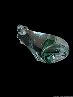 Side angle showing clear glass and green swirls on the frog body, highlighting the hand blown glass characteristics.