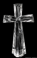 Front view of large vintage solid crystal glass cross figurine, showing clear faceted crystal design with geometric planes and polished surfaces, against black background.