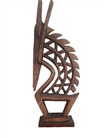 Side view of the carved wooden antelope head dress sculpture showing the intricate geometric cutout pattern and detailed horn carving.