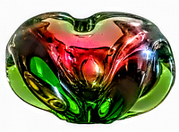 Top view of mid century heavy hand blown art glass ashtray showing red and green color blend and organic shape, measuring 6 inches diameter.