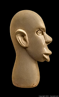 Side profile view of the soapstone sculpture showing detailed carving of the face and ears with smooth finish on light gray stone.