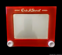 Front view of the vintage Etch A Sketch featuring its red frame, white knobs, and branded screen.