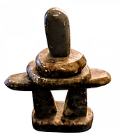 Full view of the vintage Indigenous stone statue showing its shape and stone texture.