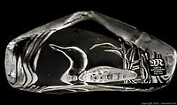 Front view of the crystal duck sculpture showing etched reed plants and the paper label with logo and text.