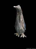 Front angled view of the vintage metal penguin sculpture showing body proportions and metal texture.