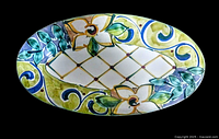 Top front view of the oval hand-painted pottery platter showing floral and geometric designs in multiple colors