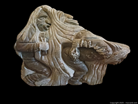 Front view of soapstone sculpture showing hooded figure carrying a bundle
