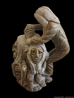 Three-quarter front view showing two figures and pinecone