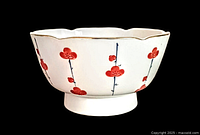 Side view of the vintage Japanese ceramic bowl showing scalloped edges and red floral hand painted design.