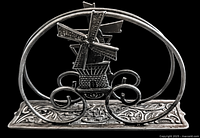 Front view of vintage pewter windmill napkin holder, showing detailed windmill and ornamental base.
