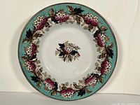 Top view of the antique English decorative bowl showing the turquoise rim and grapevine pattern around the edge and in the center.