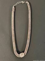 Full view of the multi-strand metallic bead necklace with central rhinestone bead and adjustable clasp.