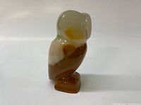 Front view of polished marble owl carving with natural brown and white marble pattern.