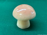 Front angle view of marble mushroom figurine showing smooth polished surface and rounded cap