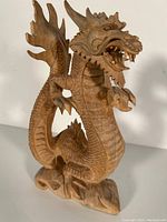Front view of the wood carved dragon showing detailed head, scales, and wings